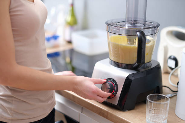 istock Woman presses start of food processor with dough 1407277343