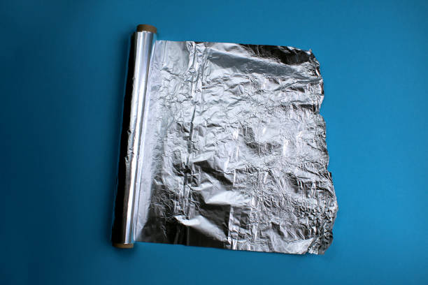istock Foil in a roll for baking lies on a blue background. 1407277768