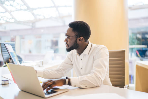 istock Black man working with documents and laptop in office 1407279007