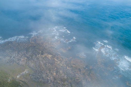 aerial view of rocky coastline with fog