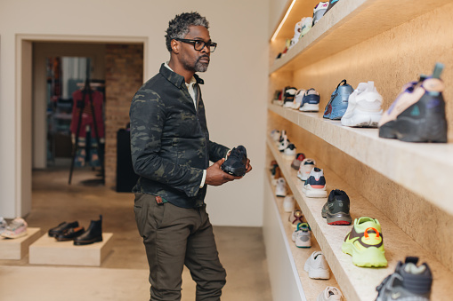 Black male shopping picking through shoes