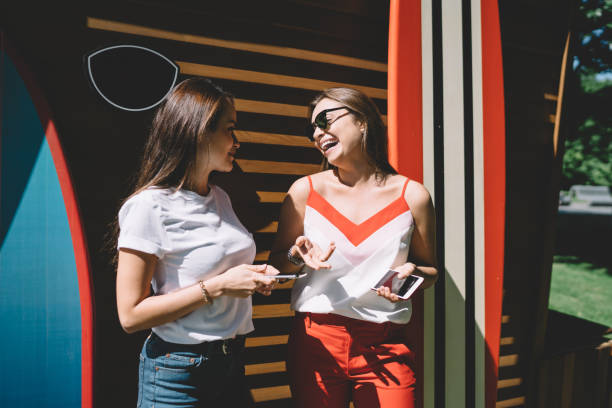 istock Happy Caucasian hipster girl satisfied with friendly conversation for discussing web content, cheerful female millennials in casual wear using smartphone devices during live meeting at sunny street 1407282744