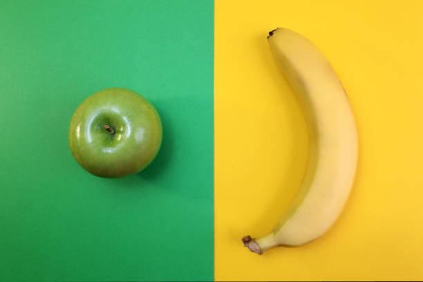 A green apple on a black reflective background