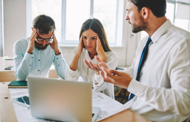 istock Tired office workers feeling headache during deadline reading email with bad news from colleague about project, unhappy male and female partners near desktop with blueprint and modern laptop computer 1407282989