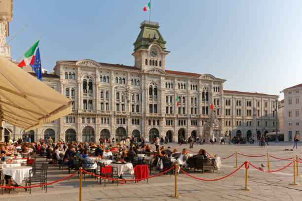 Crowd at Caffè degli Specchi and City Hall in Trieste stock photo