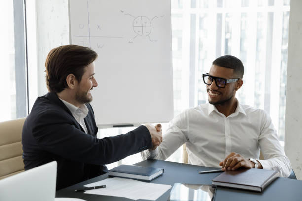 istock Multi ethnic business partners succeed goal, finish meeting with handshake 1407283500