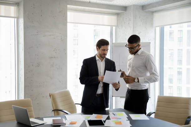 istock Multiethnic businessmen consider documents, share information working in boardroom 1407283763