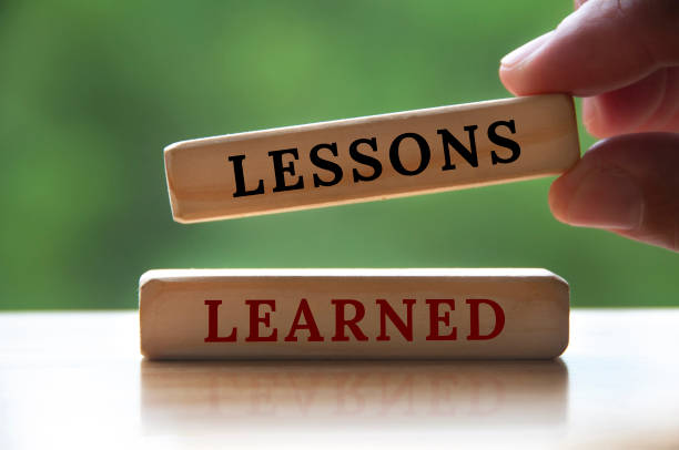 istock Lessons learned text on wooden blocks with hand holding and blurred nature background. Learning concept 1407283870