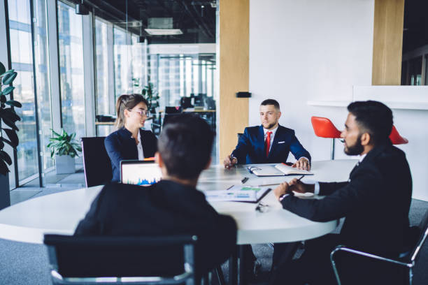 istock Colleagues sitting at round table in modern conference room during meeting 1407284099