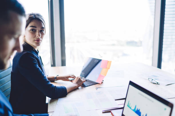 istock Colleagues working on laptops in bright office 1407284173