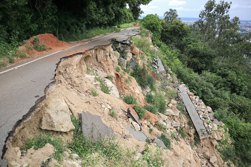 A Dramatic picture of an Asphalted road damaged due to the Landslide during Monsoon season in a Hill range in Karnataka, India.