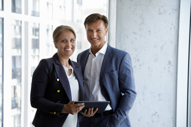 istock Middle-aged businesspeople pose in office with digital tablet 1407285170