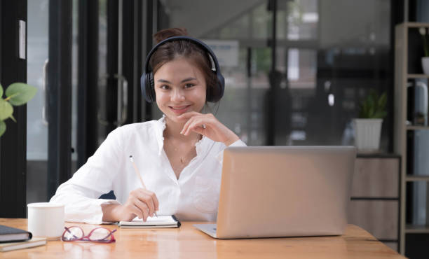 istock girl practicing online Use a laptop and a wireless headset. looking at camera 1407285847