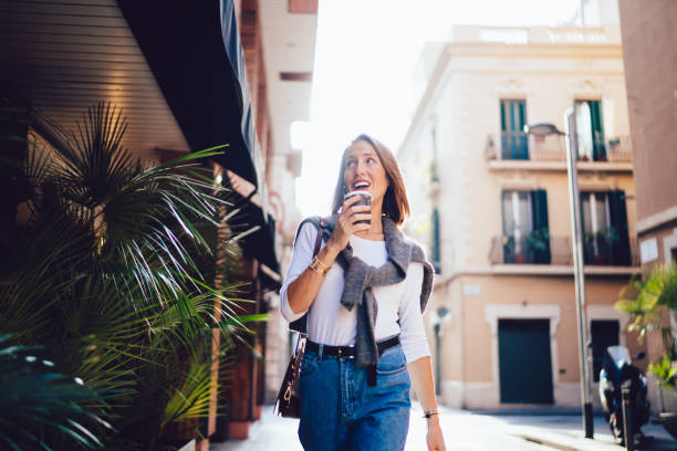 istock Happy lady strolling on street with coffee 1407286030