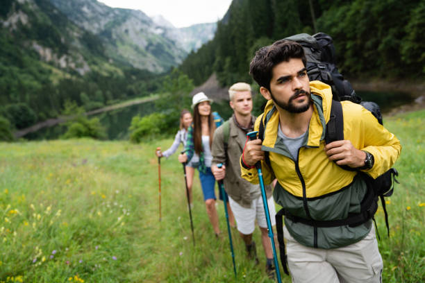 istock Group of friends hiking together outdoors exploring the wilderness and having fun 1407287113