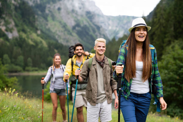 Group of friends with backpacks doing trekking excursion on mountain