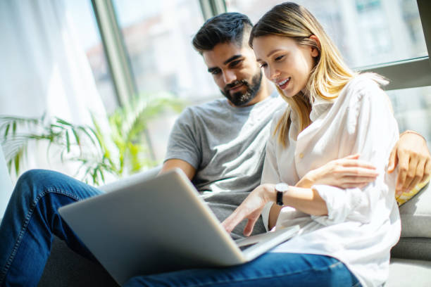 Young couple using a laptop at home.