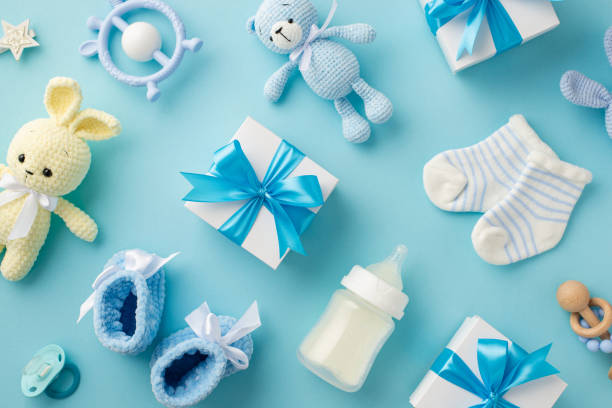 istock Baby accessories concept. Top view photo of gift boxes teether knitted bunny and teddy-bear toys socks booties soother milk bottle star and rattle on isolated pastel blue background 1407292007