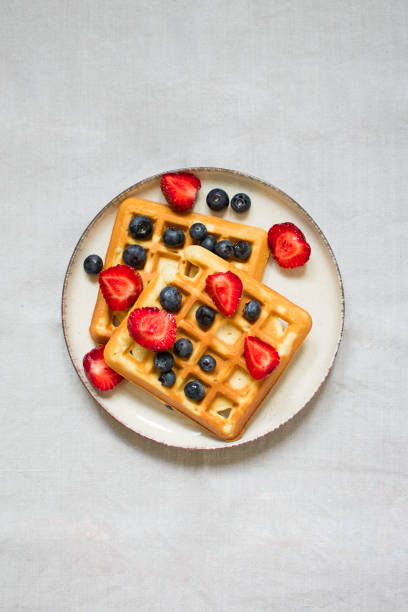istock Traditional belgian waffles with fresh berries on grey background 1407294978
