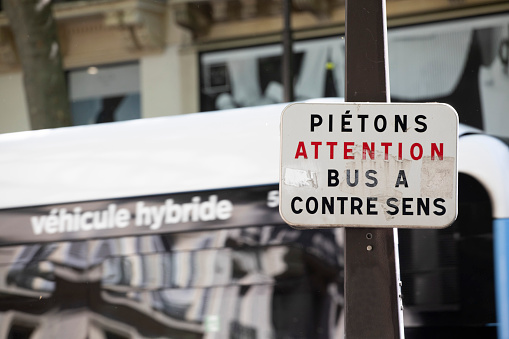 Sign in French translated as 'pedestrians beware, bus travelling in the opposite direction'