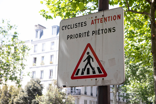 Sign in French translated as 'cyclists warning, pedestrians have priority'