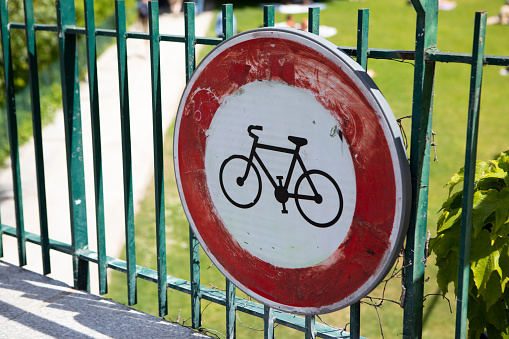 Cycling prohibited sign on the fence to a public park in Paris
