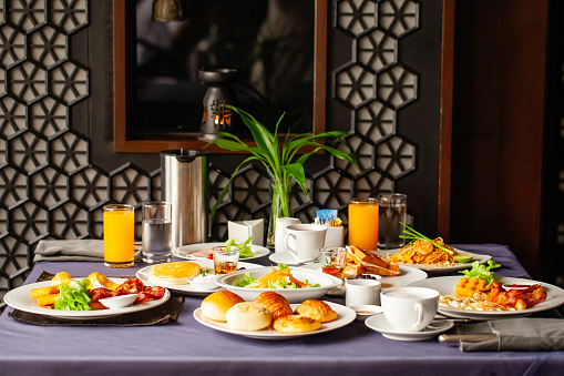 Food and drinks served on table for two persons on breakfast or brunch at morning in restaurant. Concept of weekend vacation, rest on holiday in modern city hotel. Dinner or lunch in cafe in resort.