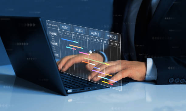 Project manager working on laptop and updating tasks and milestones progress planning with Gantt chart scheduling interface for company on virtual screen. Business Project Management System. Project manager working on laptop and updating tasks and milestones progress planning with Gantt chart scheduling interface for company on virtual screen. Business Project Management System progress report stock pictures, royalty-free photos & images