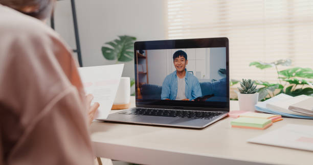 istock Close up of young Asian woman using laptop making video call with customer while working in office. 1407301257