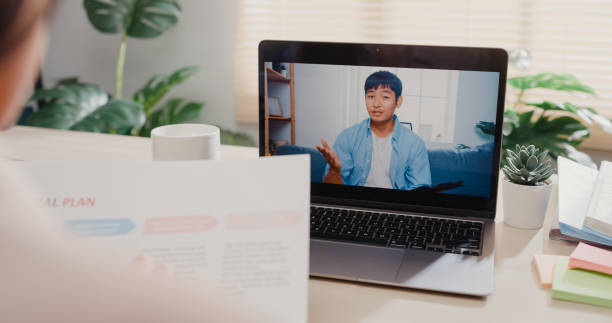 istock Close up of young Asian woman using laptop making video call with customer while working in office. 1407301276