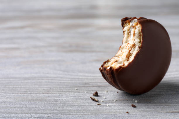 istock Tasty bitten choco pie on white wooden table, closeup. Space for text 1407301428