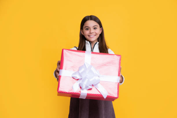 istock positive girl with present box on yellow background 1407302229