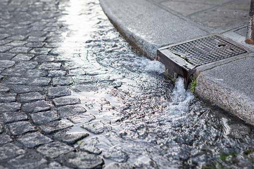 Paris streets are cleaned by water from a curb-side opening which washes debris into the sewer system