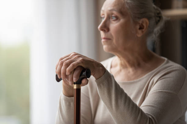 istock Upset lonely grey-haired older woman holds walking stick 1407303673