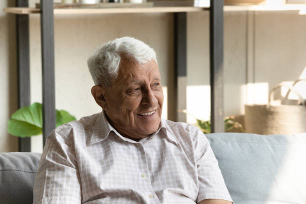 istock Carefree elderly man relaxing at home seated on comfy couch 1407303759
