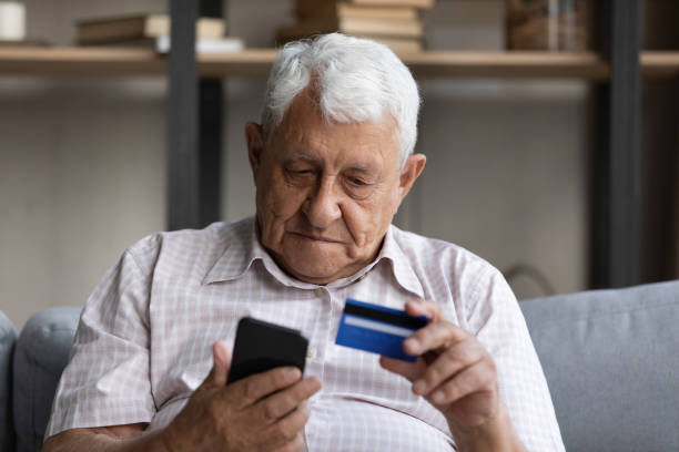 Senior man makes instant money transfer use smartphone and card