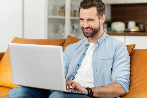 istock Young bearded hipster guy is typing on the laptop 1407308797