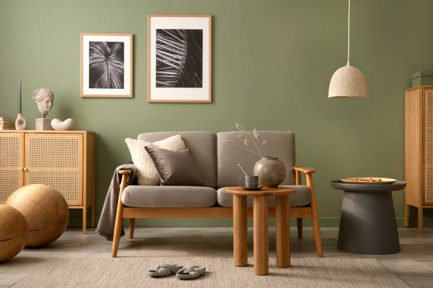 istock Elegant composition of living room interior. Modern scandi sofa, design pillows, side table, rattan commode and creative personal accessories. Sage green wall. Template. Copy space. 1407309515