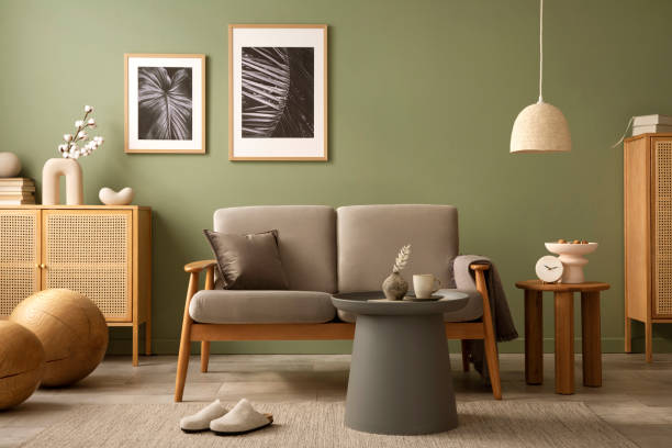 istock Elegant composition of living room interior. Modern scandi sofa, design pillows, side table, rattan commode and creative personal accessories. Sage green wall. Template. Copy space. 1407309540