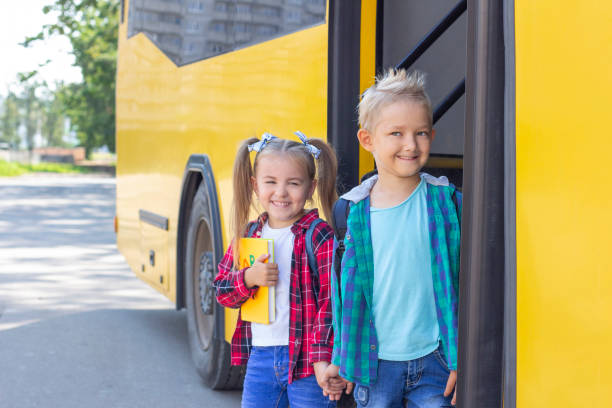 istock happy schoolchildren with backpacks get off the school bus. 1407309596