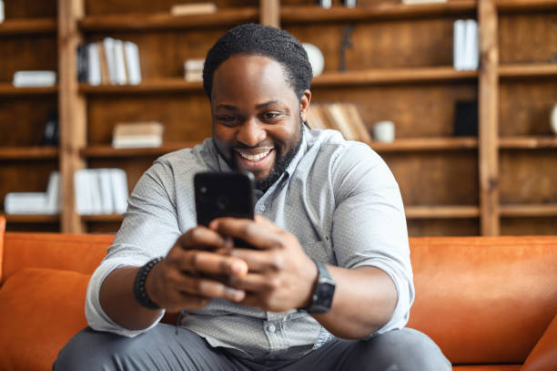 istock Happy laughing mixed-race man watching funny video 1407309613