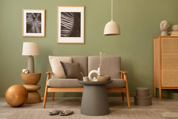 istock Elegant composition of living room interior. Modern scandi sofa, design pillows, side table, rattan commode and creative personal accessories. Sage green wall. Template. Copy space. 1407309715