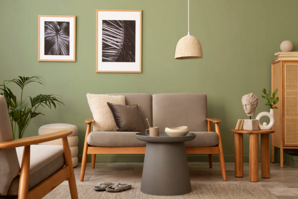 istock Elegant composition of living room interior. Modern scandi sofa, side table, rattan commode, plants and creative personal accessories. Sage green wall. Template. Copy space. 1407309749