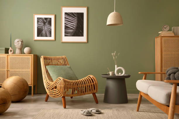 istock Creative living room interior composition with boho chair, mock up frames, commodes and personal accessories. Sage green wall. Template. Copy space. 1407309777