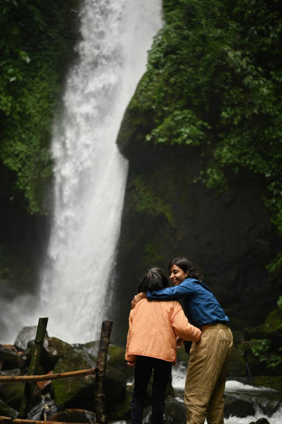 istock Mother and daughter enjoying at a majestic waterfall 1407310749