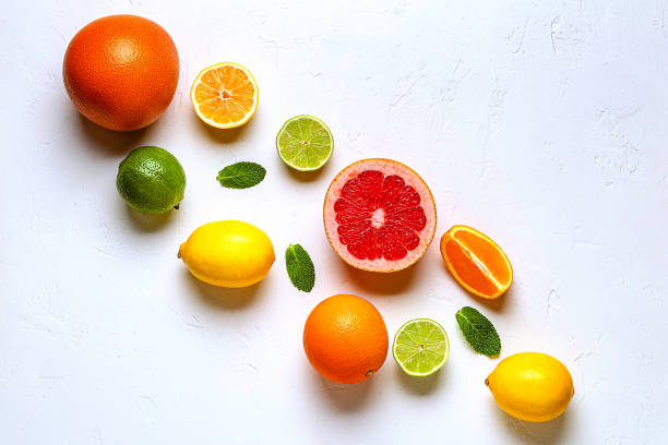 istock Fresh lemon, orange, grapefruit, lime, green leaves on light background, top view. 1407311061