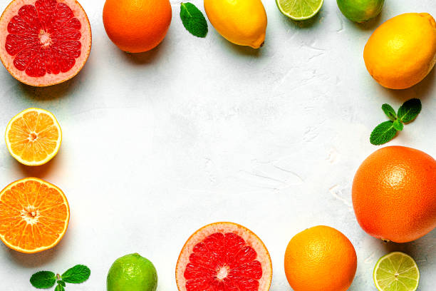 istock Fresh lemon, orange, grapefruit, lime, green leaves on light background, top view. 1407311170