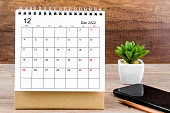 The December 2022 desk calendar on wooden table.