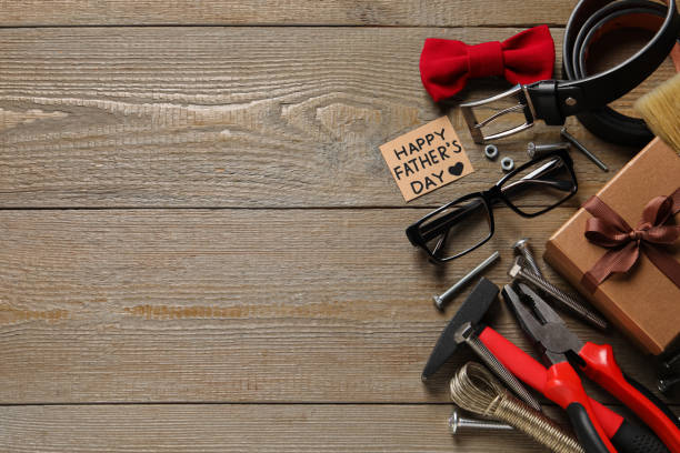 istock Card with phrase Happy Father's Day, different tools and men accessories on wooden background, flat lay. Space for text 1407311745
