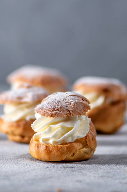 Homemade profiteroles with cream Homemade profiteroles with cream on light background choux pastry photos stock pictures, royalty-free photos & images